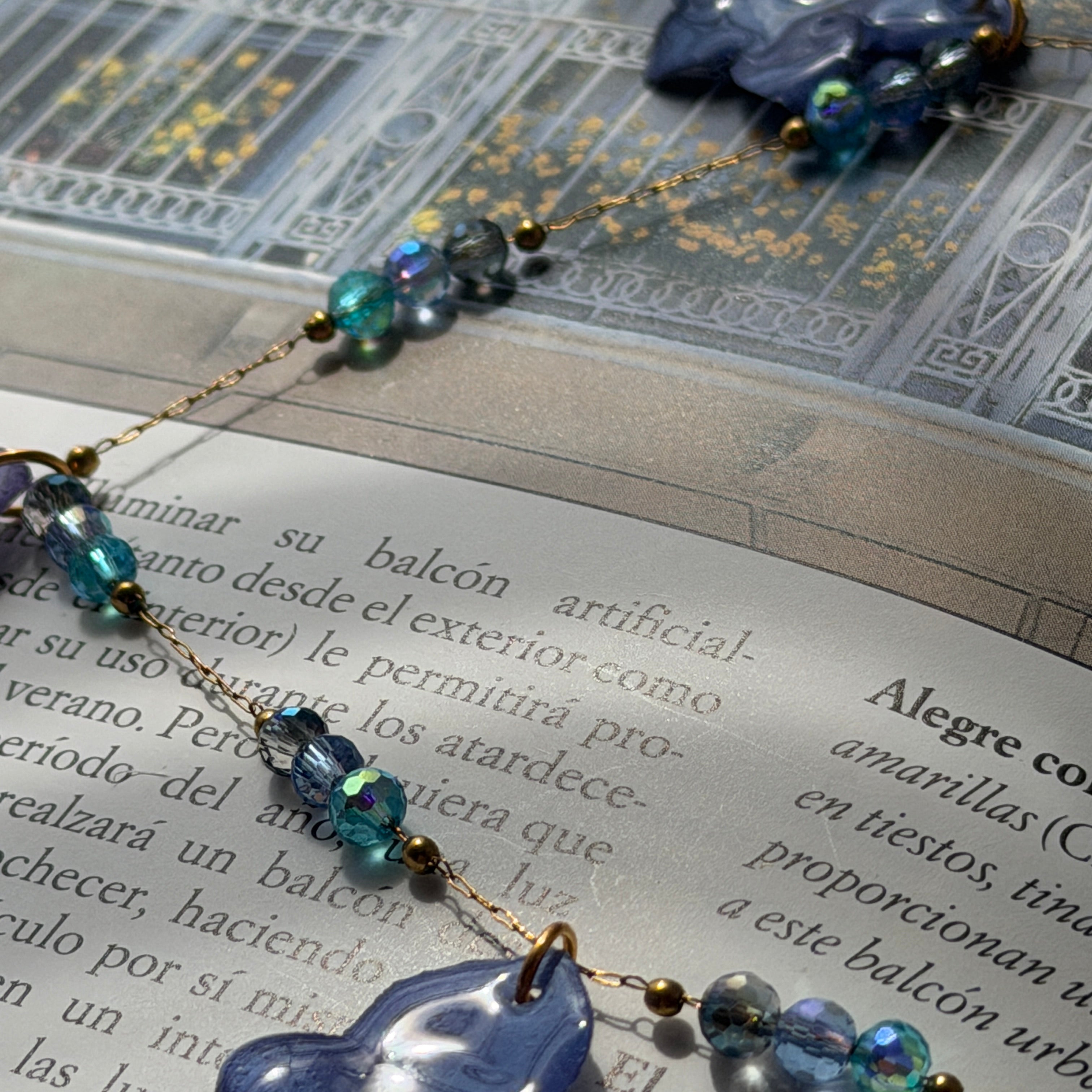 Detalle del Collar Hortensia Celeste: flores lavanda en resina con cuentas de cristal azul iridiscentes