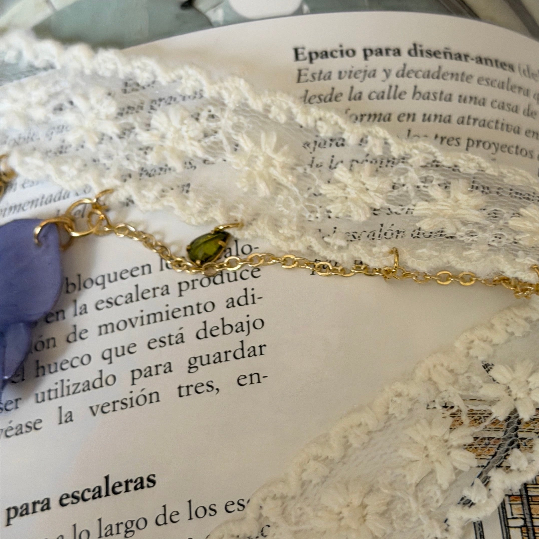 Detalle Gargantilla Nocturno: encaje crema con cadena dorada y gota de cristal verde peridoto