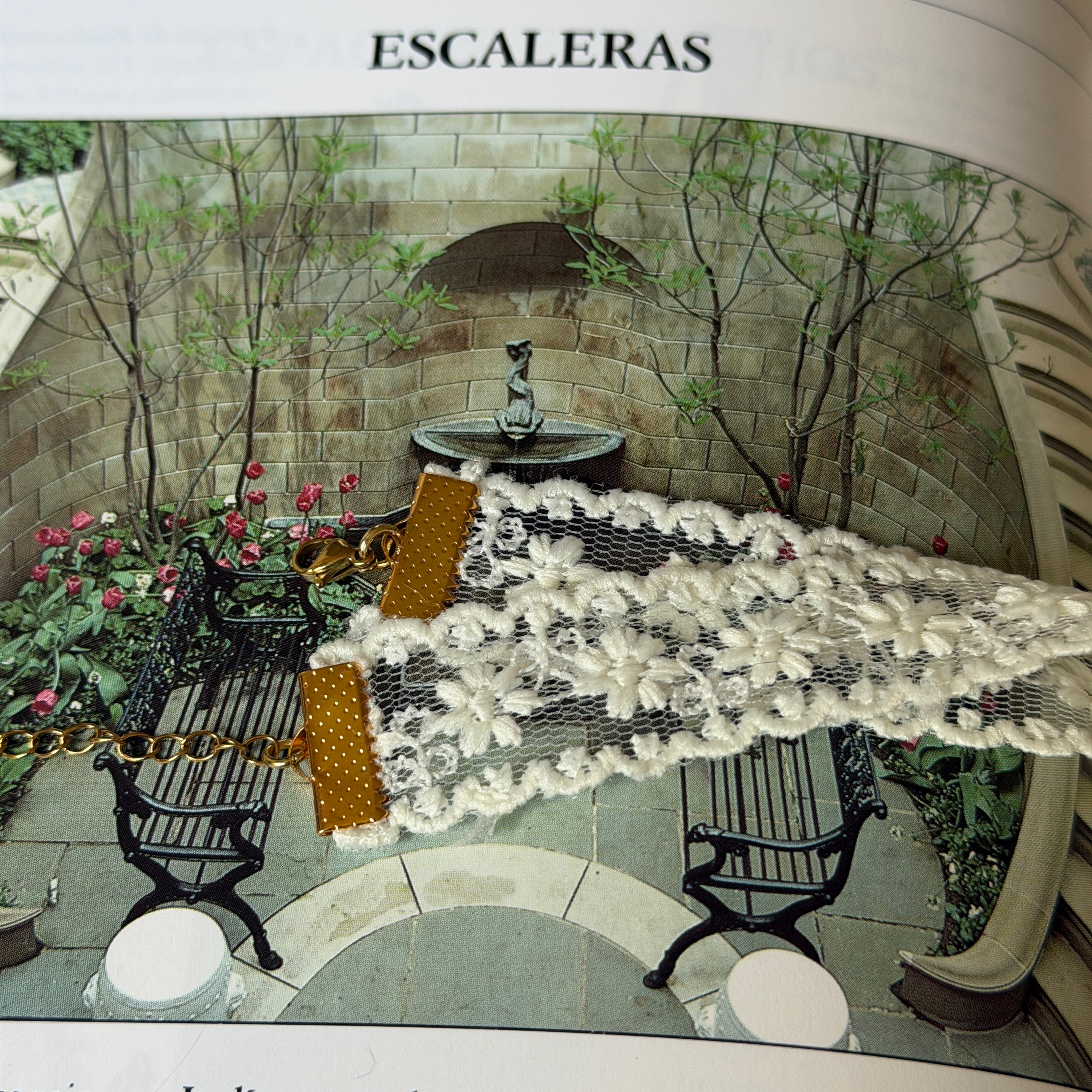 Gargantilla Nocturno y cierre dorado sobre libro con jardín de escaleras de piedra al fondo