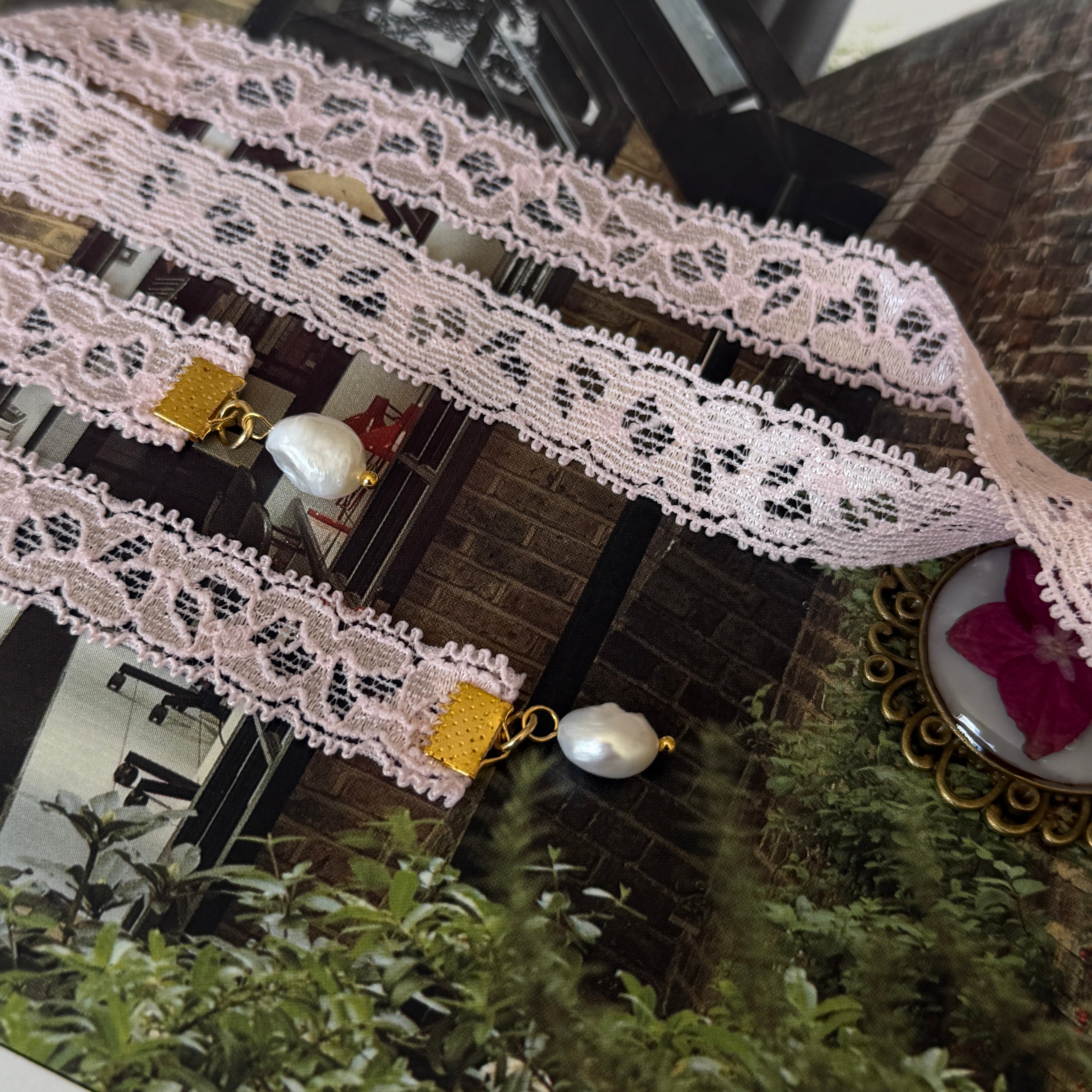 Gargantilla Serenata: encaje rosa con perlas barrocas doradas y cierre dorado con medallón bronce