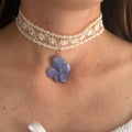 Modelo con Gargantilla Hortensia Soneto: encaje crema con colgante de hortensia azul lavanda en resina