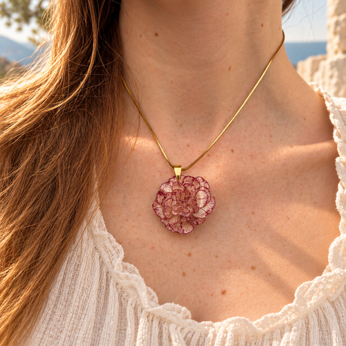 Modelo con el Collar Clavel Nácar: clavel natural marfil de vetas carmesí y cadena snake dorada