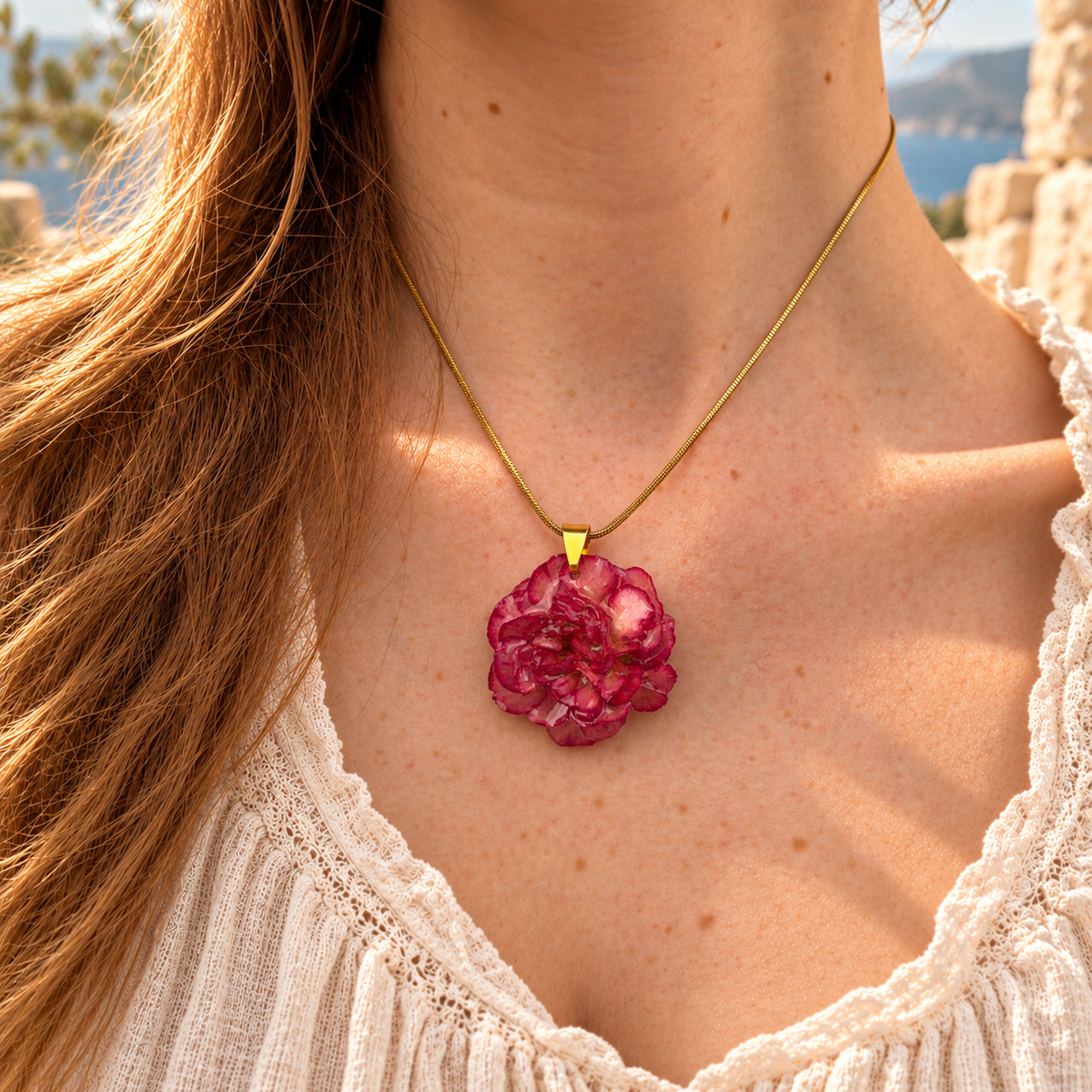 Modelo con el Collar Clavel Júpiter: clavel natural rosa y fucsia en resina con cadena snake dorada