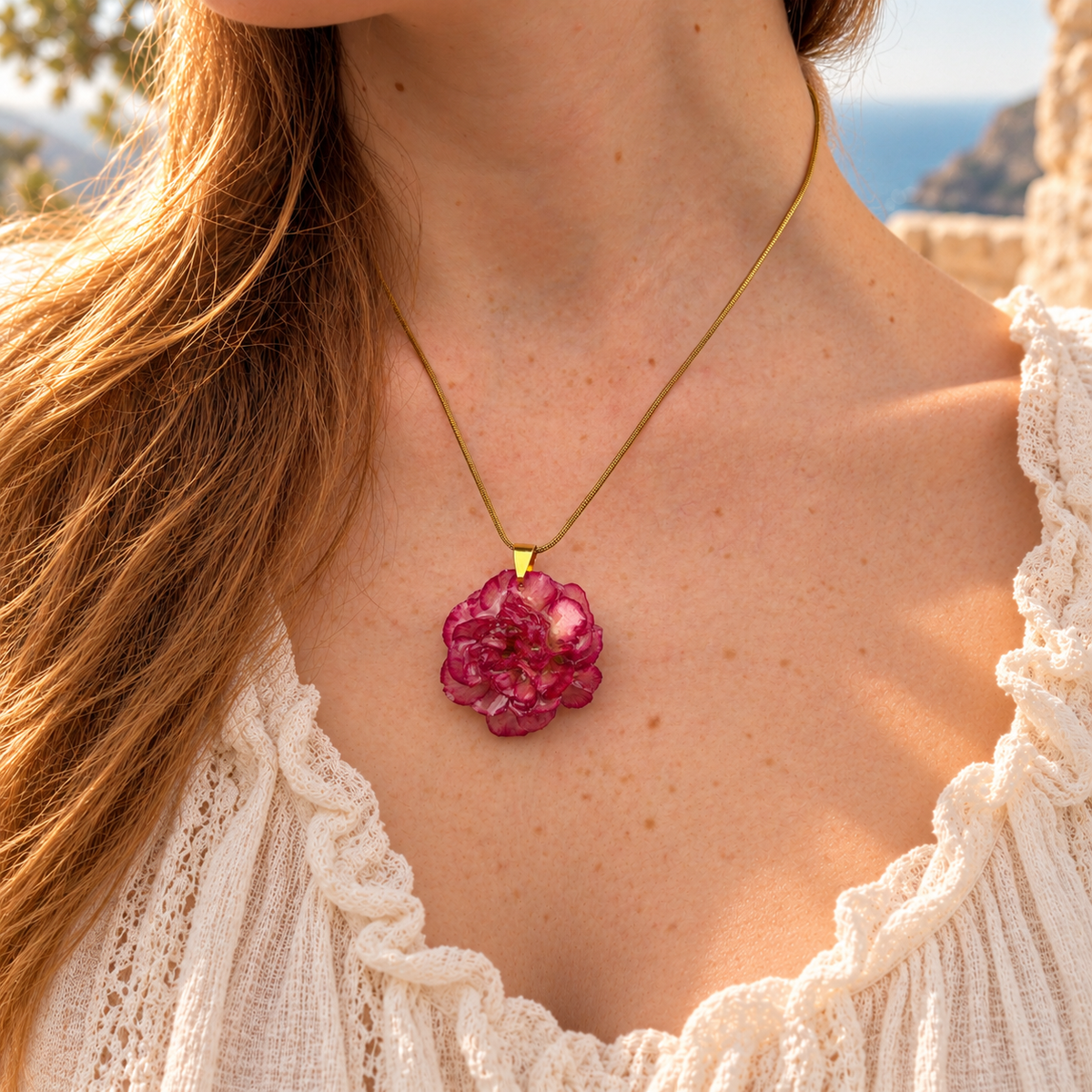 Collar Clavel Júpiter puesto con blusa blanca, clavel fucsia preservado en resina y cadena dorada