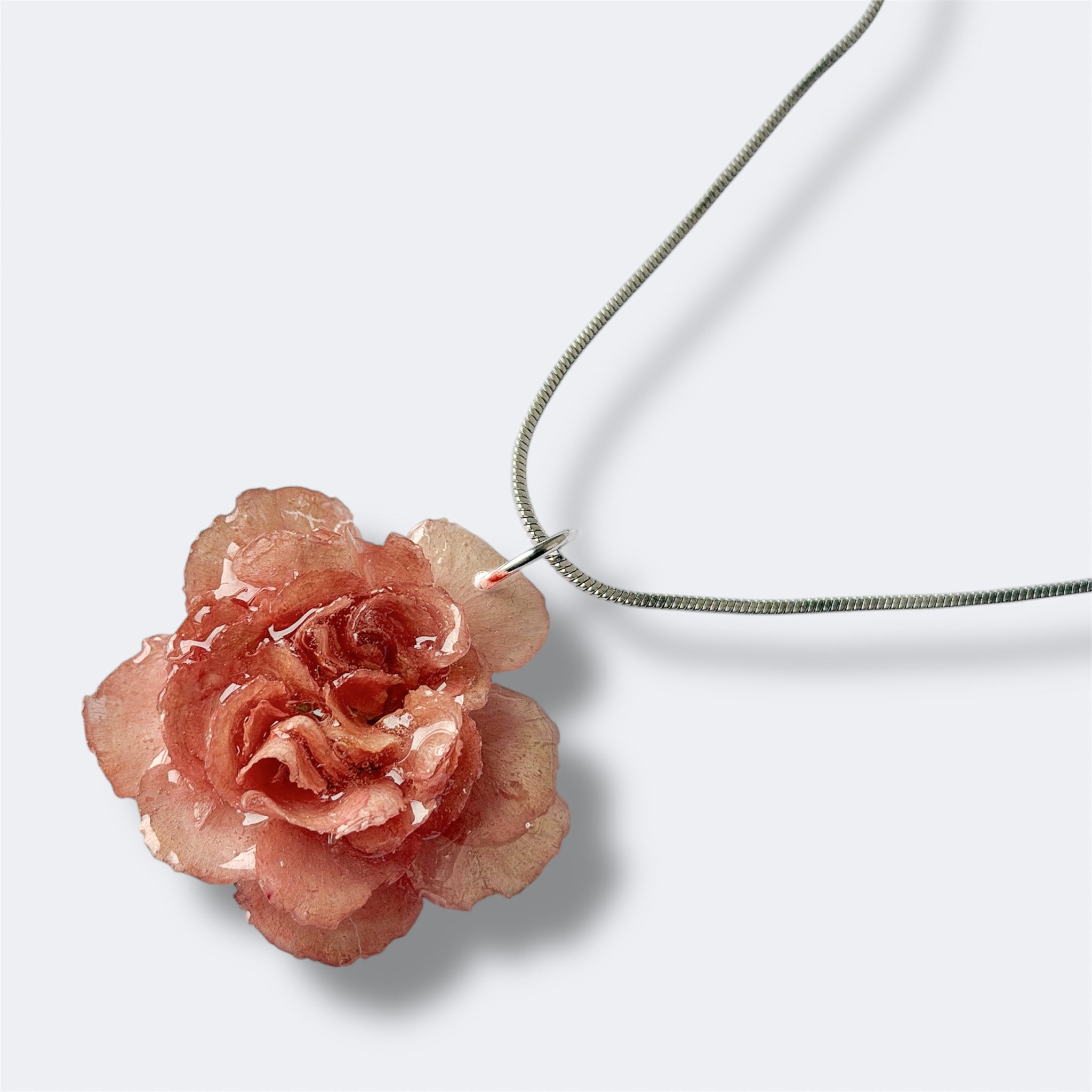 Detalle collar Clavel Aura con pétalos coral rosado preservados en resina