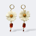 Par de pendientes de margarita blanca con cuenta ámbar rectangular y gota cristal ámbar, aros dorados, fondo gris