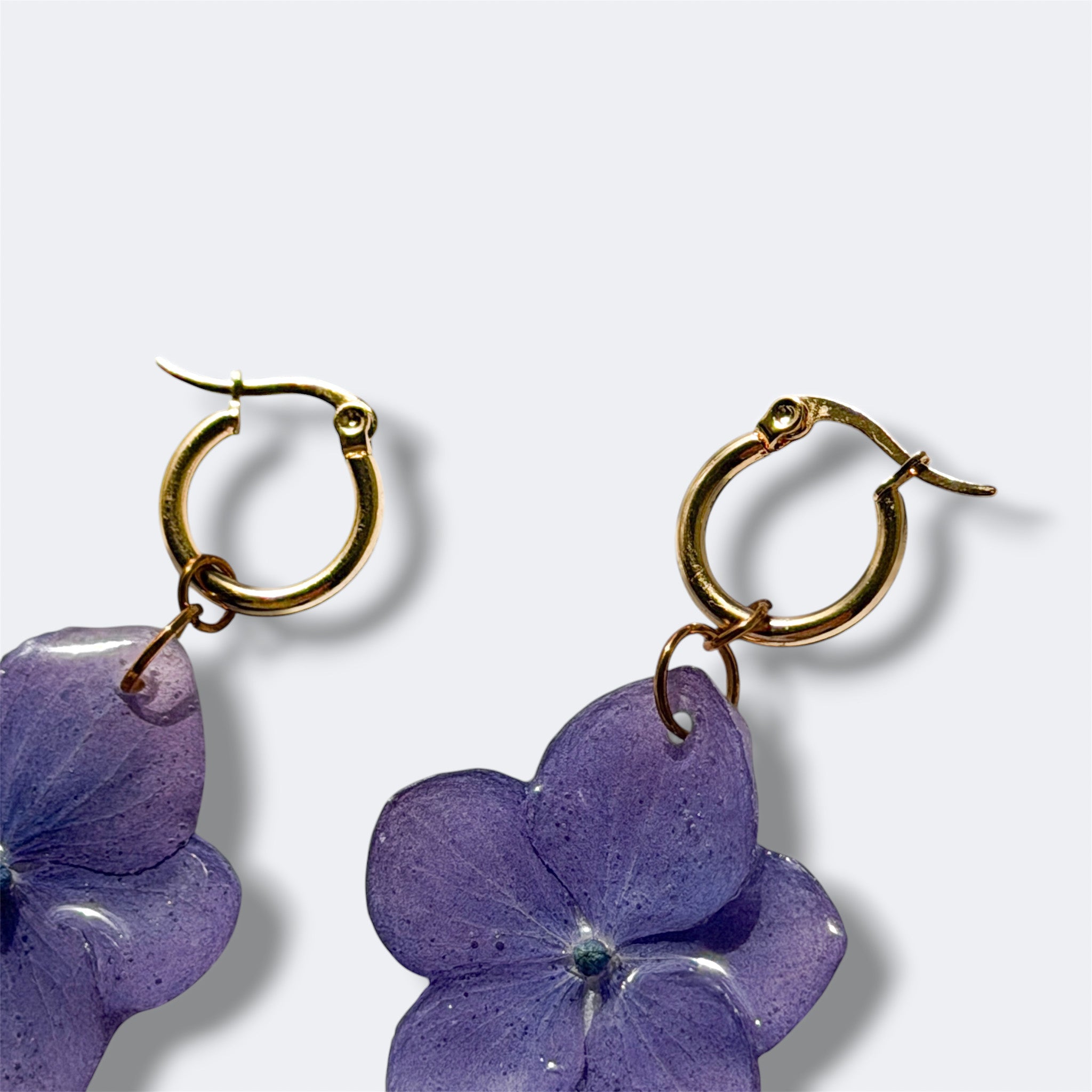 Detalle del aro dorado abierto de los Pendientes Hortensia Lavanda con hortensia azul violeta en resina