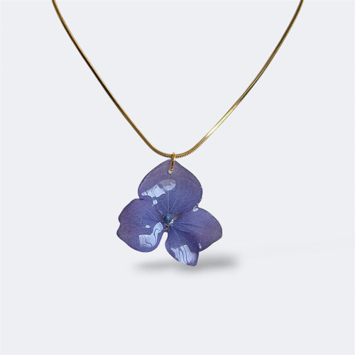 Collar colgante de hortensia lavanda natural preservada en resina con cadena serpiente dorada, fondo gris
