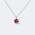 Collar Hortensia Mireia: medallón circular dorado con hortensia fucsia preservada en resina, cadena dorada