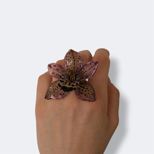 Anillo Orquídea Velaria en mano, gran orquídea marrón con manchas oscuras preservada en resina