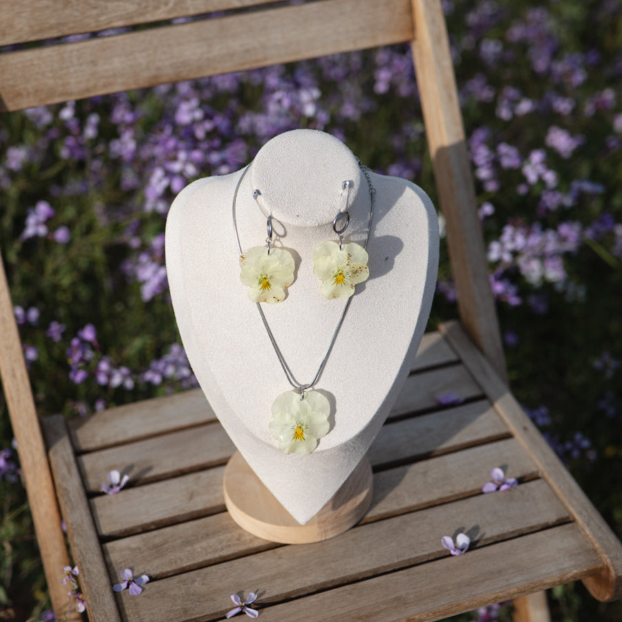 Busto display con collar y pendientes Pensamiento Alborada en silla de jardín, campo de lavanda