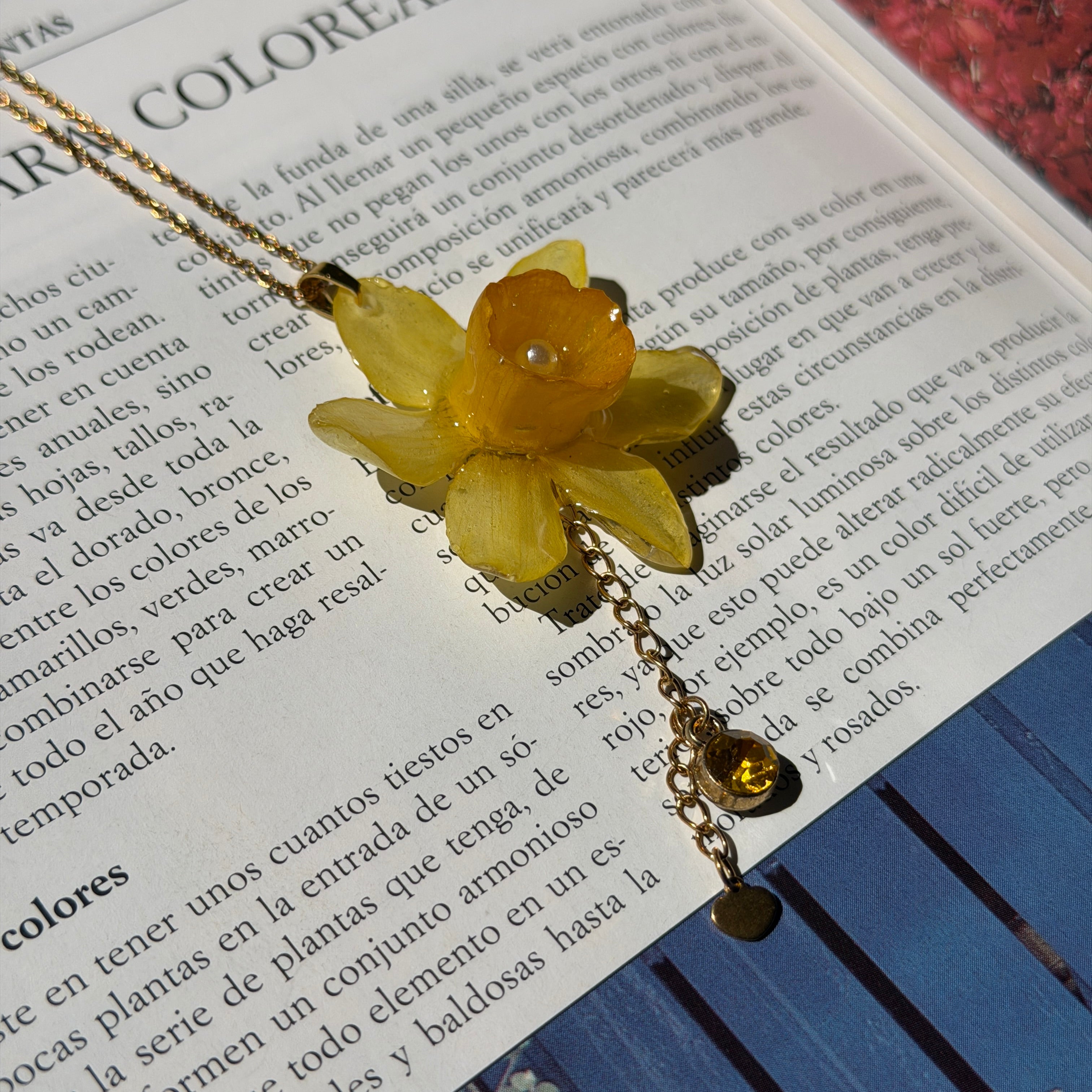 Mujer llevando collar de narciso amarillo encapsulado en resina sobre el escote