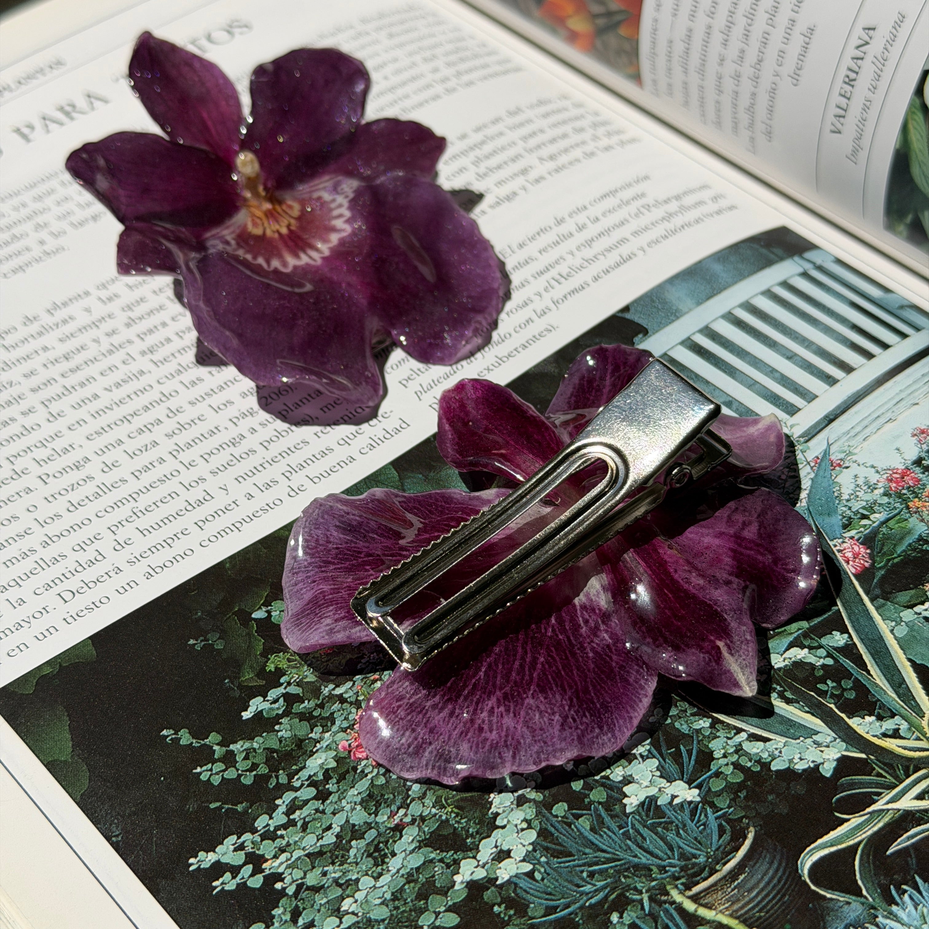 Mujer llevando pinza de orquidea morada encapsulada en resina sobre el pelo recogido