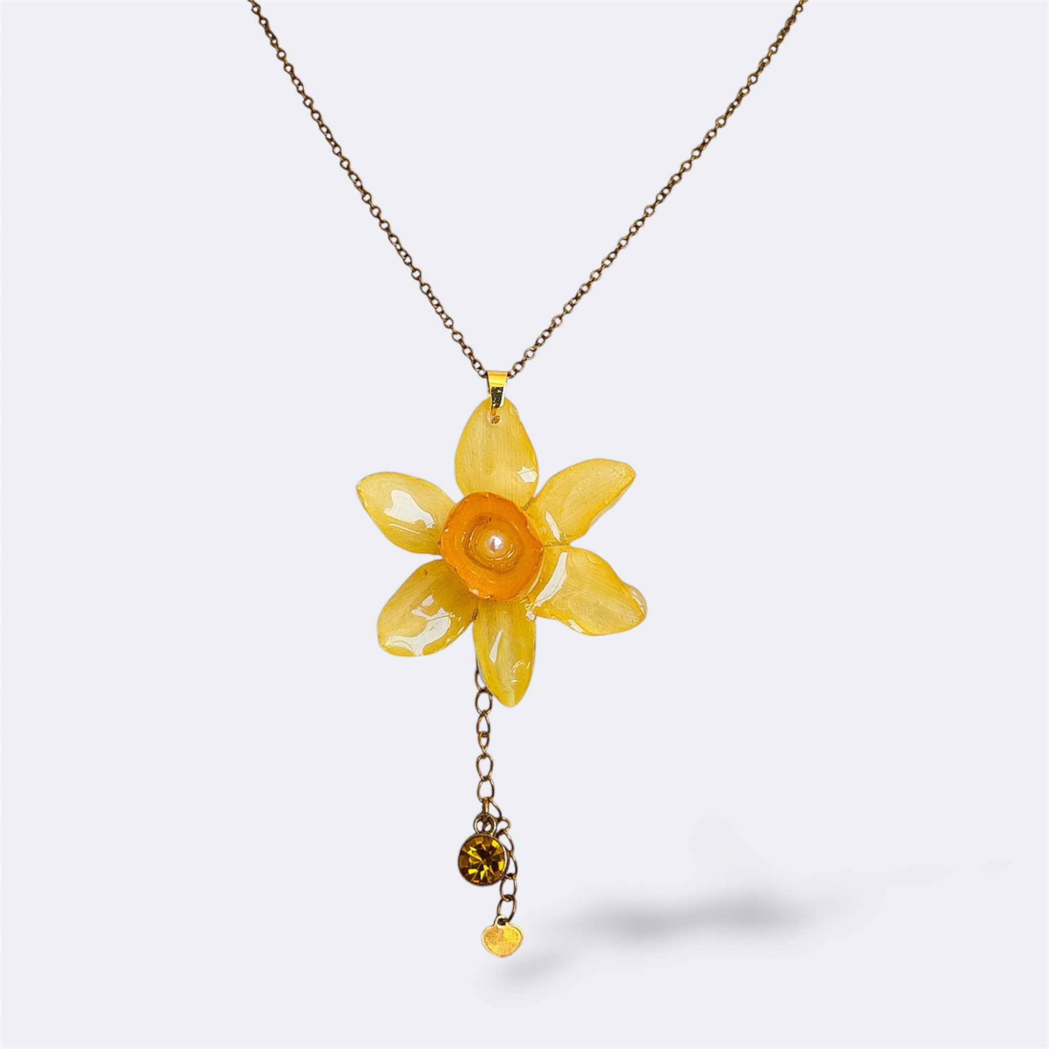 Collar con narciso amarillo encapsulado en resina, sobre cadena de acero inoxidable con cola y strass