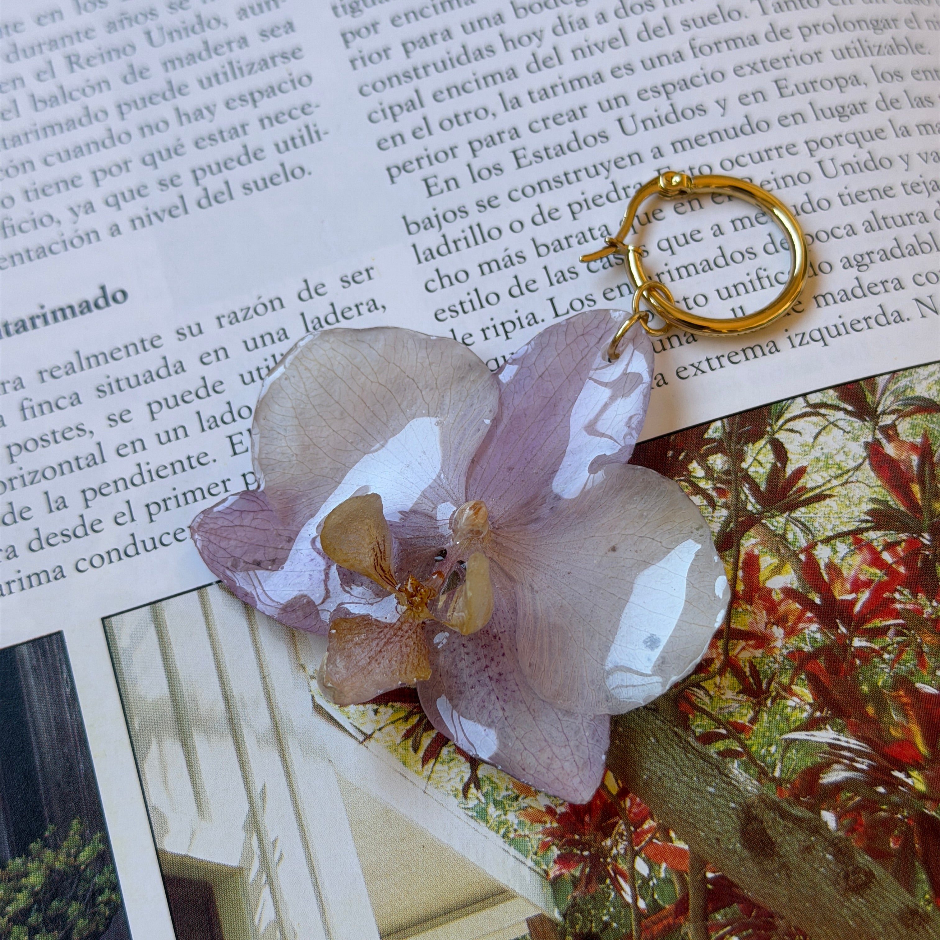 Detalle de orquídea lila real preservada en resina, con venas a la vista y labio en ámbar