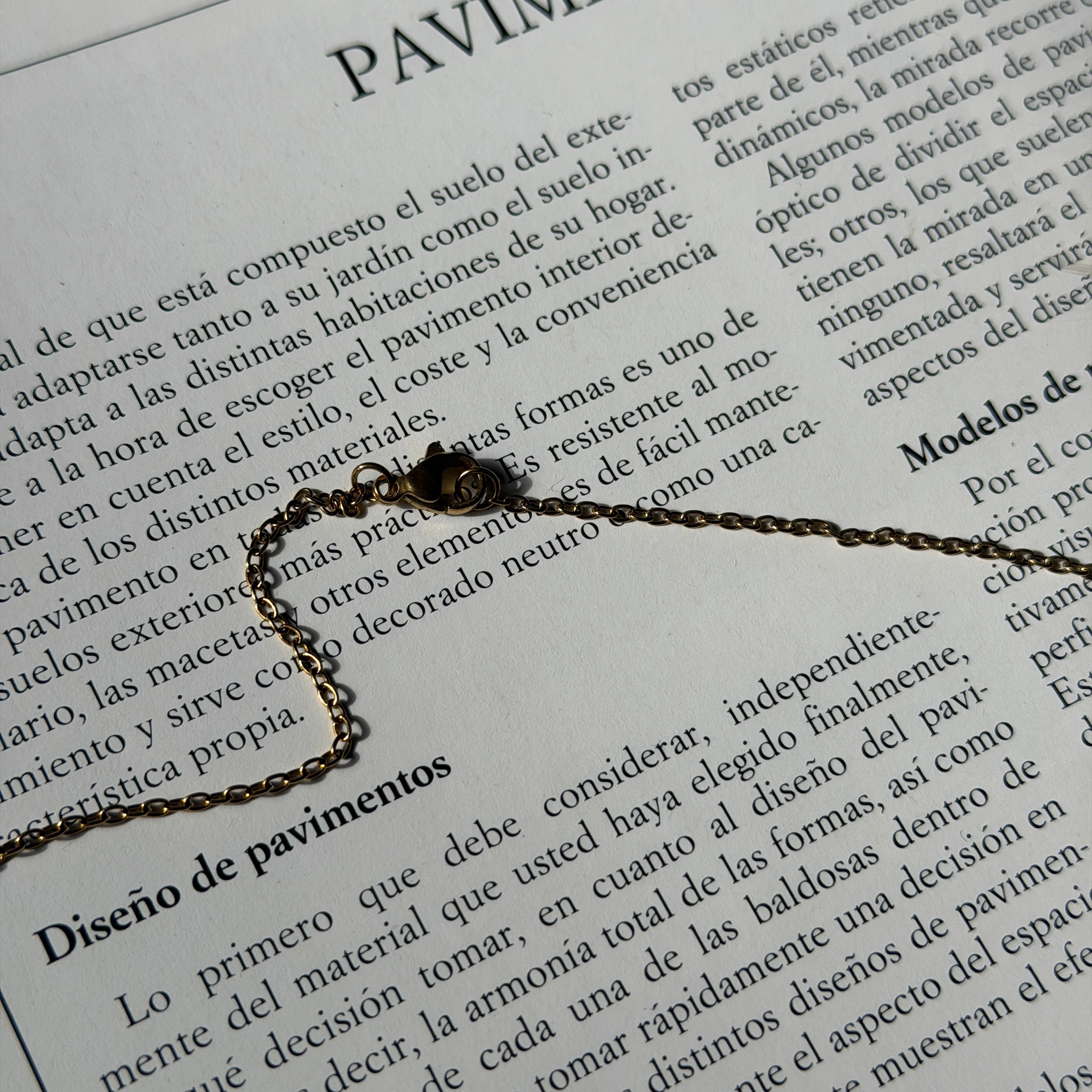 Detalle de la cadena fina de acero inoxidable con cierre de mosquetón