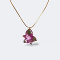 Mujer llevando collar de hortensia morada y verde encapsulada en resina sobre el escote