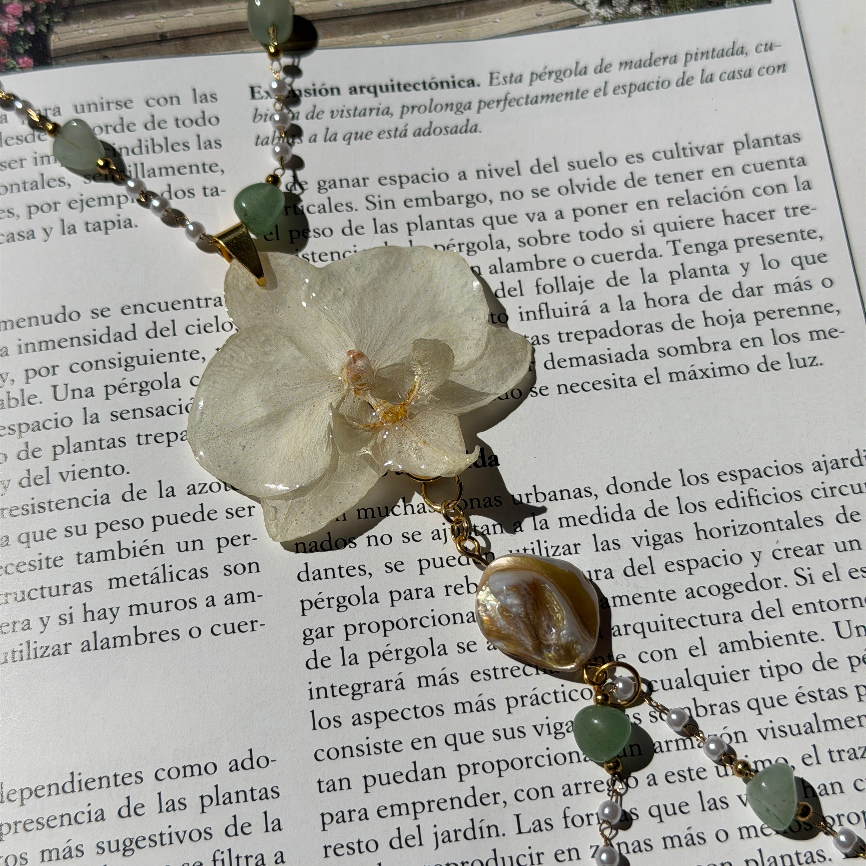 Detalle de orquídea blanca real preservada en resina, centro amarillo dorado y columna rosada