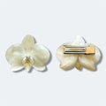 Pinza con orquídea marfil encapsulada en resina, vista frontal y trasera