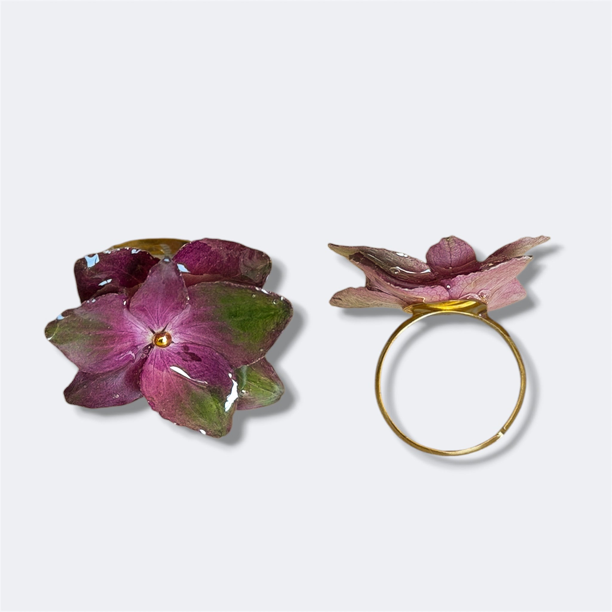 Anillo con hortensias magenta y verdes encapsuladas en resina, vista frontal y lateral del aro de acero inoxidable