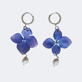 Pendientes de hortensia azul violáceo encapsulada en resina, con perla barroca y aros de acero inoxidable
