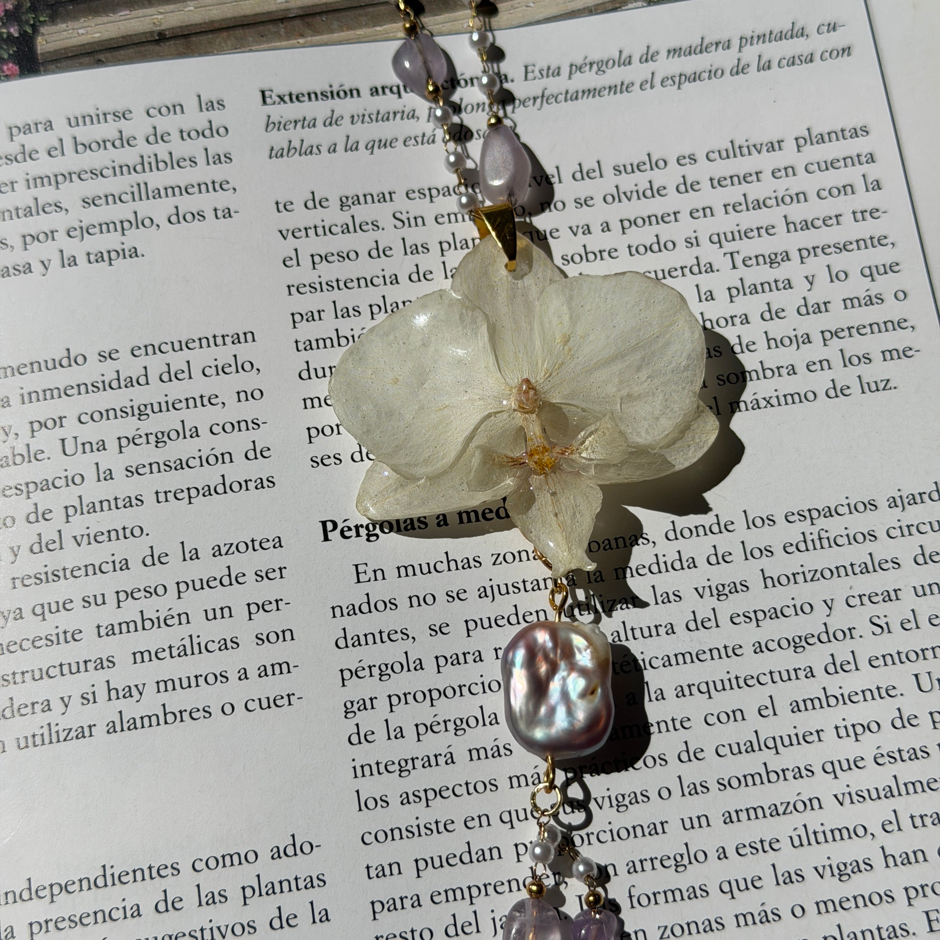 Detalle de orquídea blanca real preservada en resina, con nervaduras visibles y centro ámbar