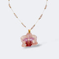 Collar con orquídea rosa real preservada en resina, sobre cadena de acero inoxidable con cuentas