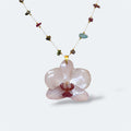 Collar con orquídea blanca encapsulada en resina, sobre cadena de piedras naturales y acero inoxidable
