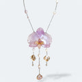 Collar con orquídea lila encapsulada en resina, sobre cadena de acero inoxidable con perlas de agua dulce